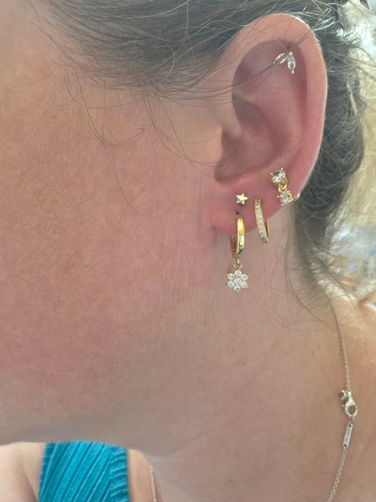 Curated ear piercings with gold hoops and studs